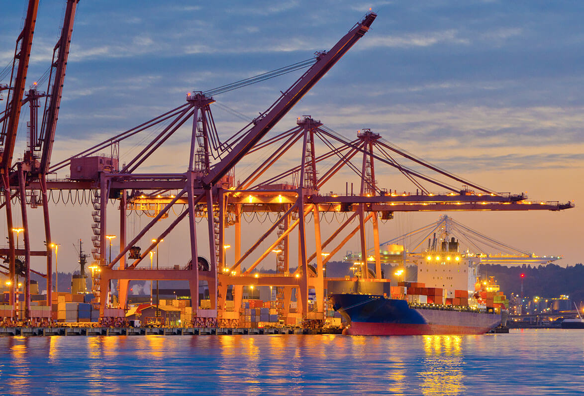 Docked container ship and cranes at dusk Docked container ship and cranes at dusk